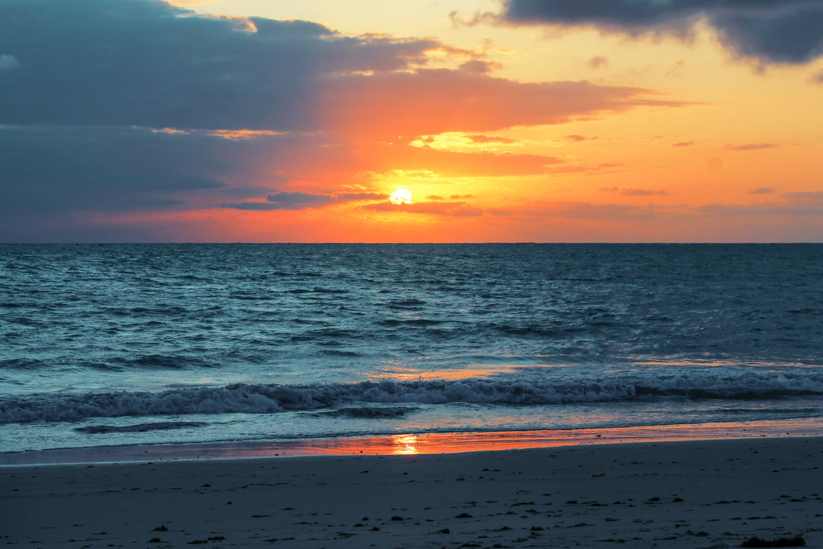 Playa al atardecer, con el sol sobre el mar