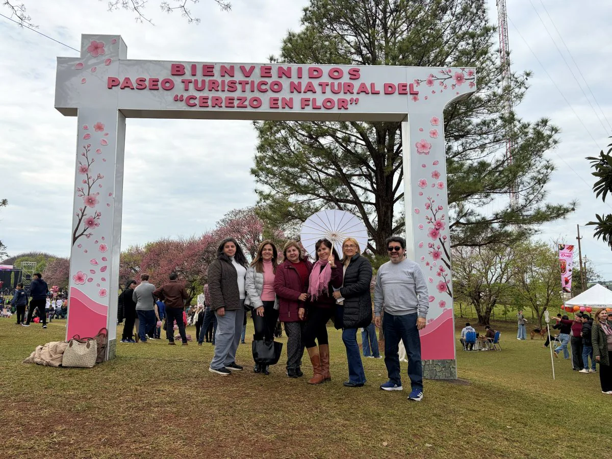 Grupo de viajeros bajo el arco de bienvenida al paseo del Cerezo en Flor